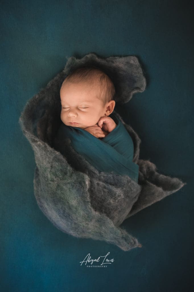 Newborn Baby wrapped in Blue felt. Photography session in Wales