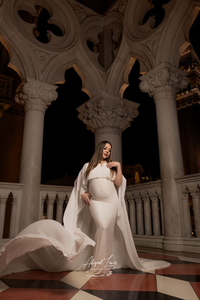 pregnant person in white dress posing in the Venetian hotel